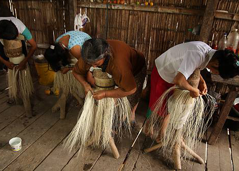 a group of women weaving Toquilla Straw Hats